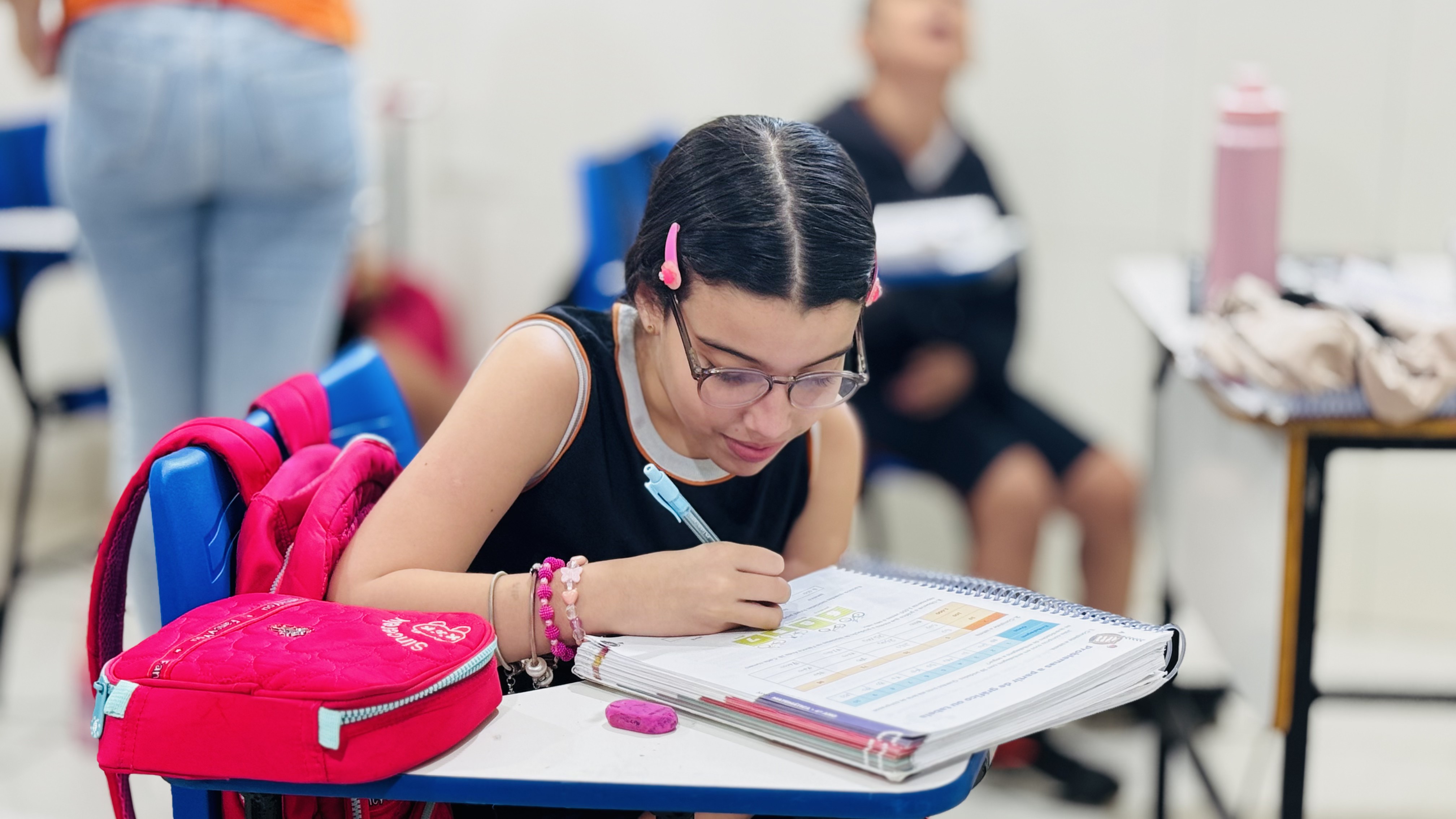 Aluna do CBU estudando e preenchendo o caderno em sala de aula